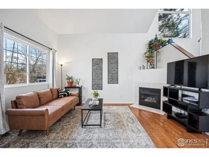 Bright staged living room with a leather sofa and fireplace